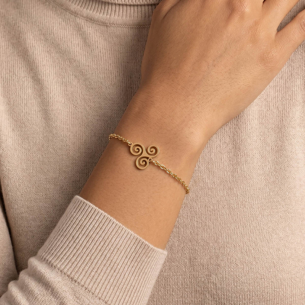 Goldfarbenes Damen Armband mit Keltischem Anhänger am Handgelenk eines Models getragen.