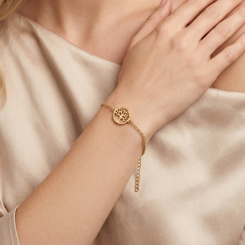 Goldfarbenes Damen Armband mit Lebensbaum Anhänger am Handgelenk eines Models getragen.