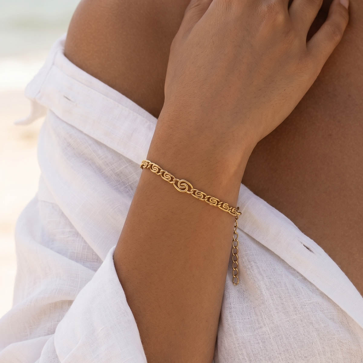 Goldfarbenes Damen Armband am Handgelenk eines Models getragen.