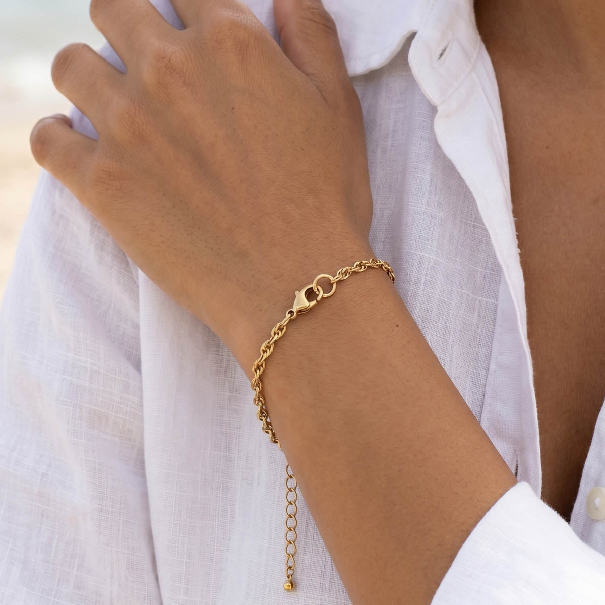 Goldfarbenes Damen Armband am Handgelenk eines Models getragen.