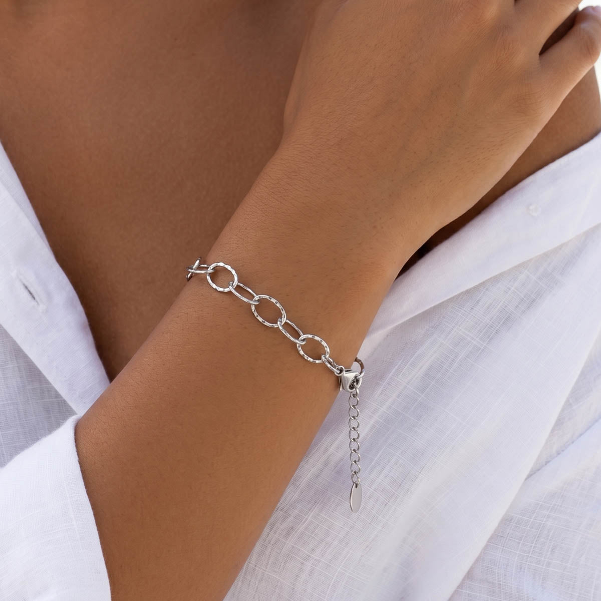 Silberfarbenes Damen Gliederarmband am Handgelenk eines Models getragen.