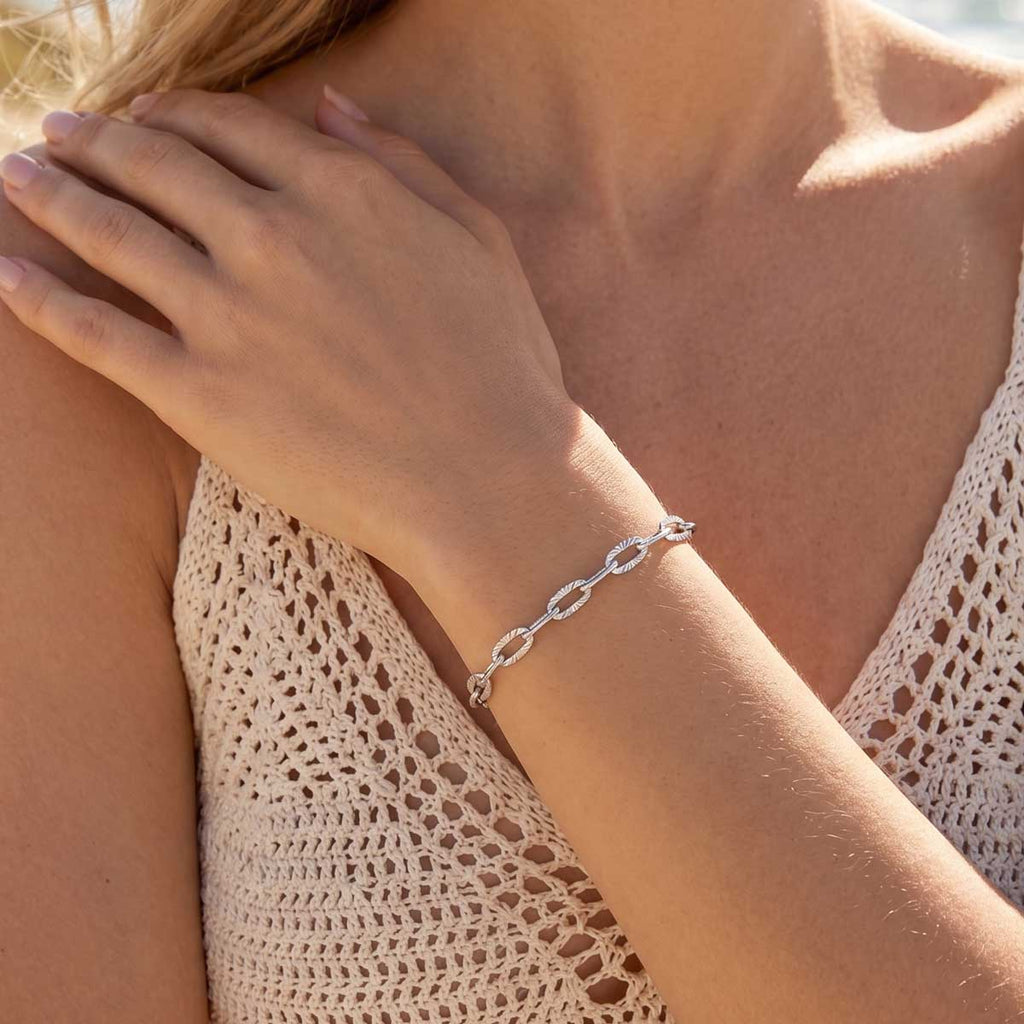 Silberfarbenes Damen Armband Armkette am Handgelenk eines Models getragen.