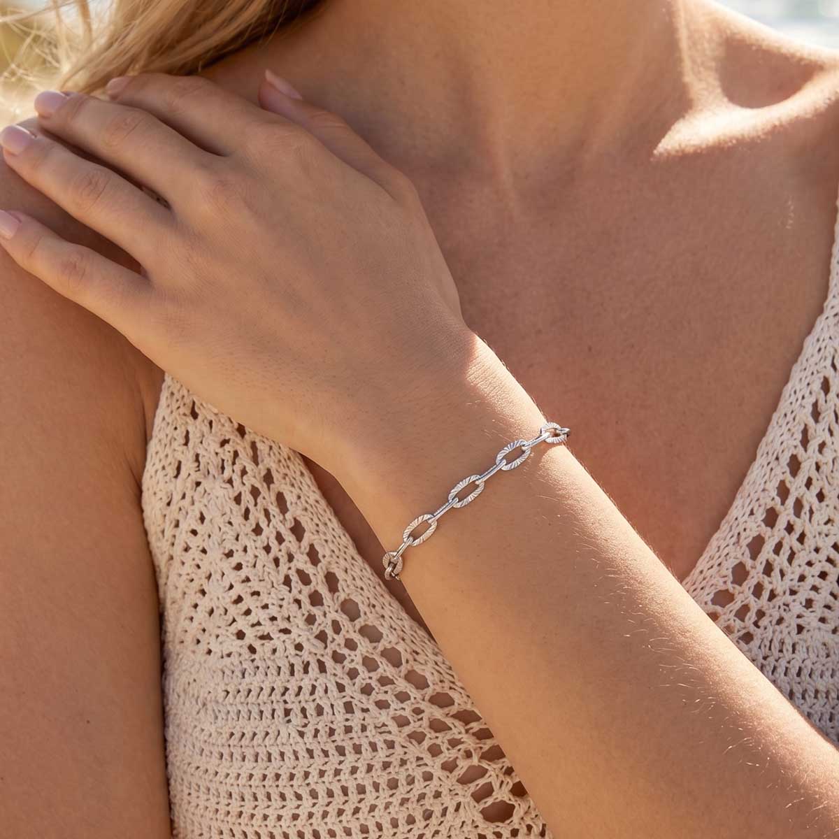 Silberfarbenes Damen Armband Armkette am Handgelenk eines Models getragen.