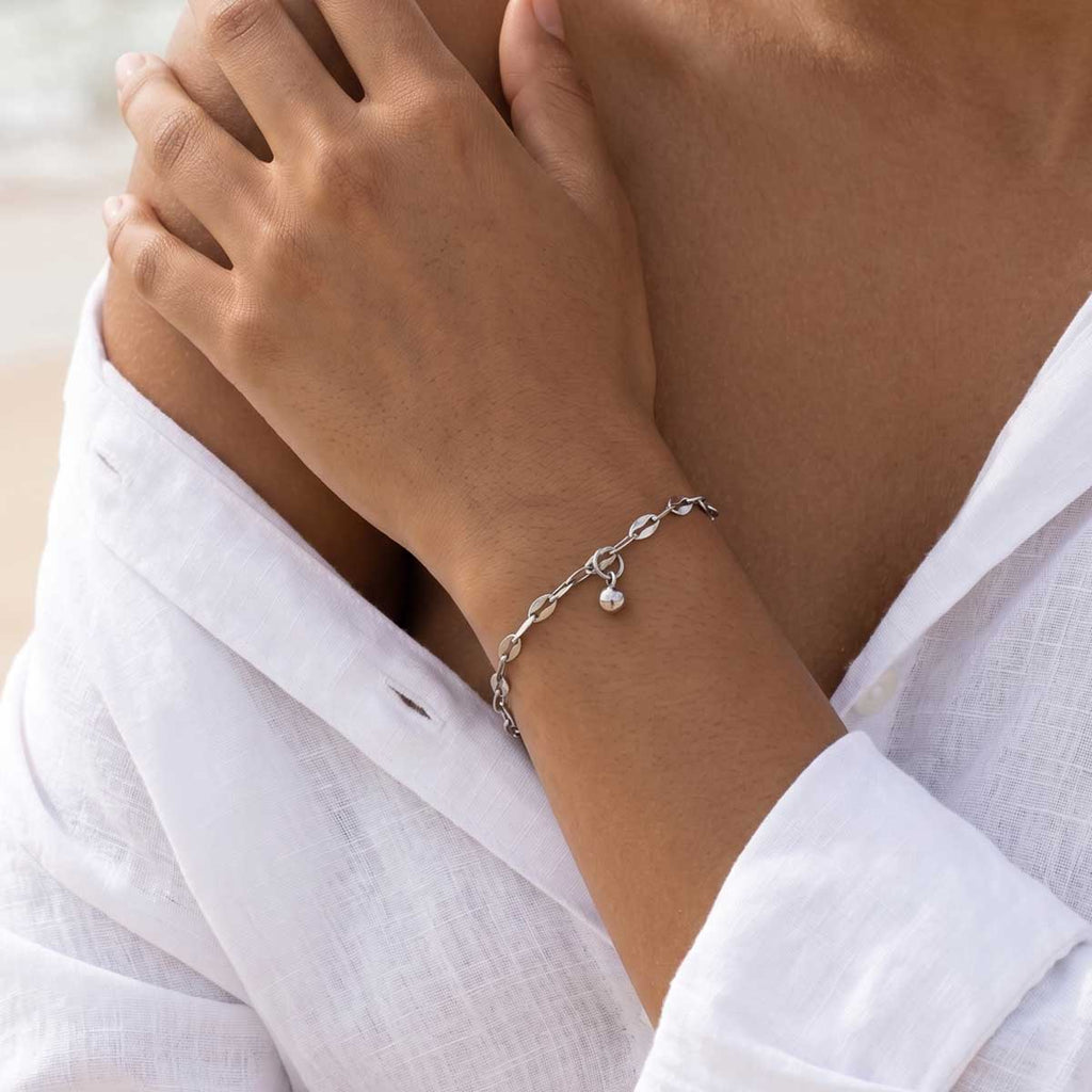 Silberfarbenes Damen Armband am Handgelenk eines Models getragen.