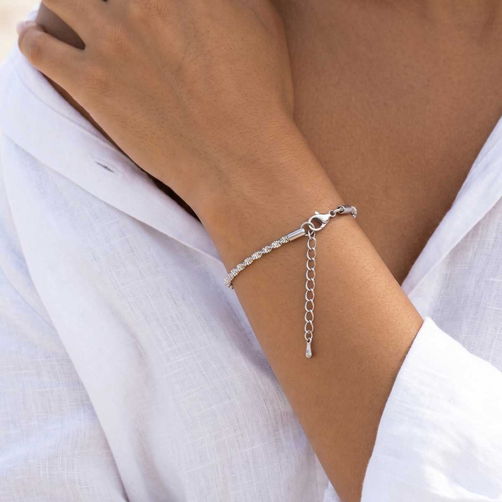 Silberfarbenes Damen Armband am Handgelenk eines Models getragen.