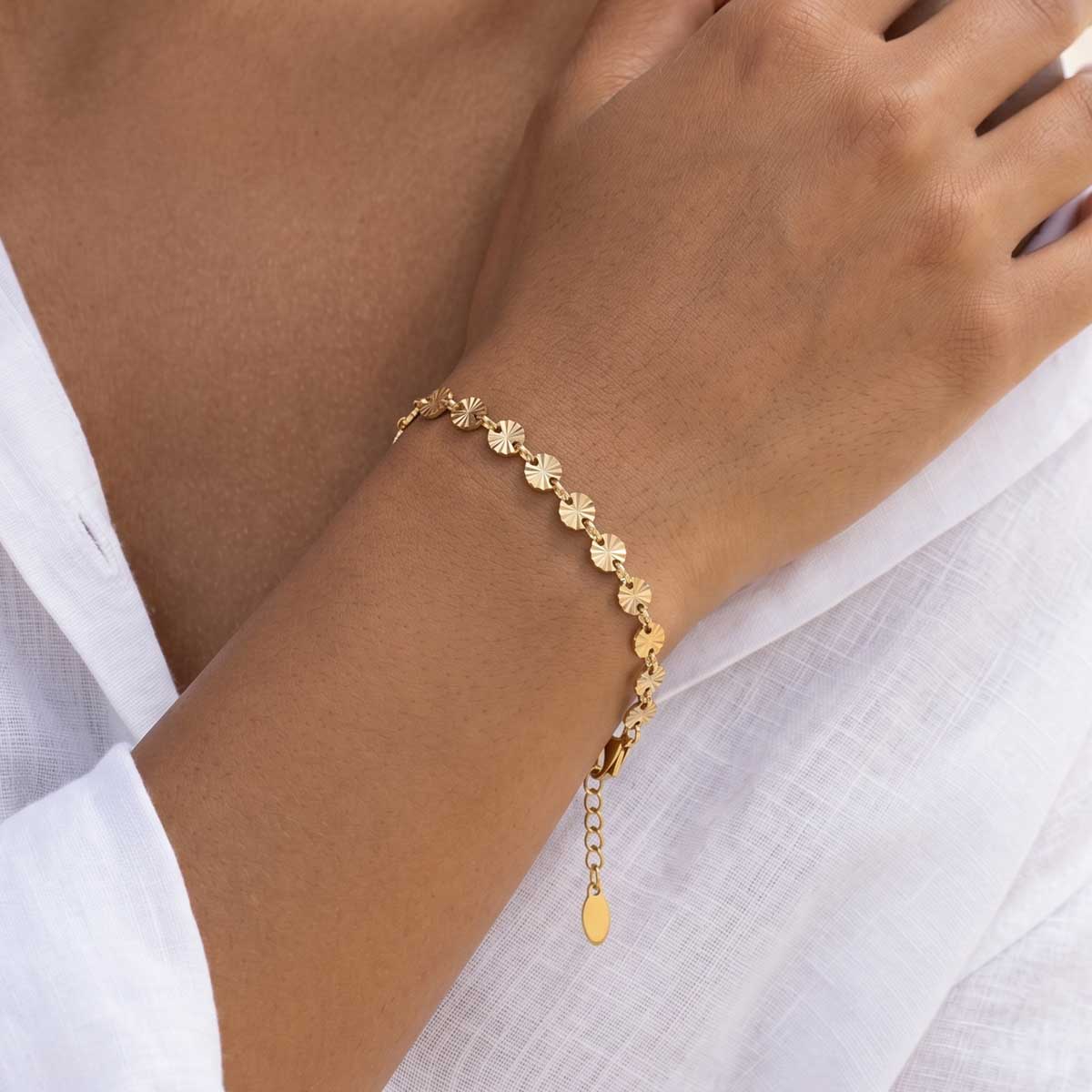 Goldfarbenes Damen Armband am Handgelenk eines Models getragen.