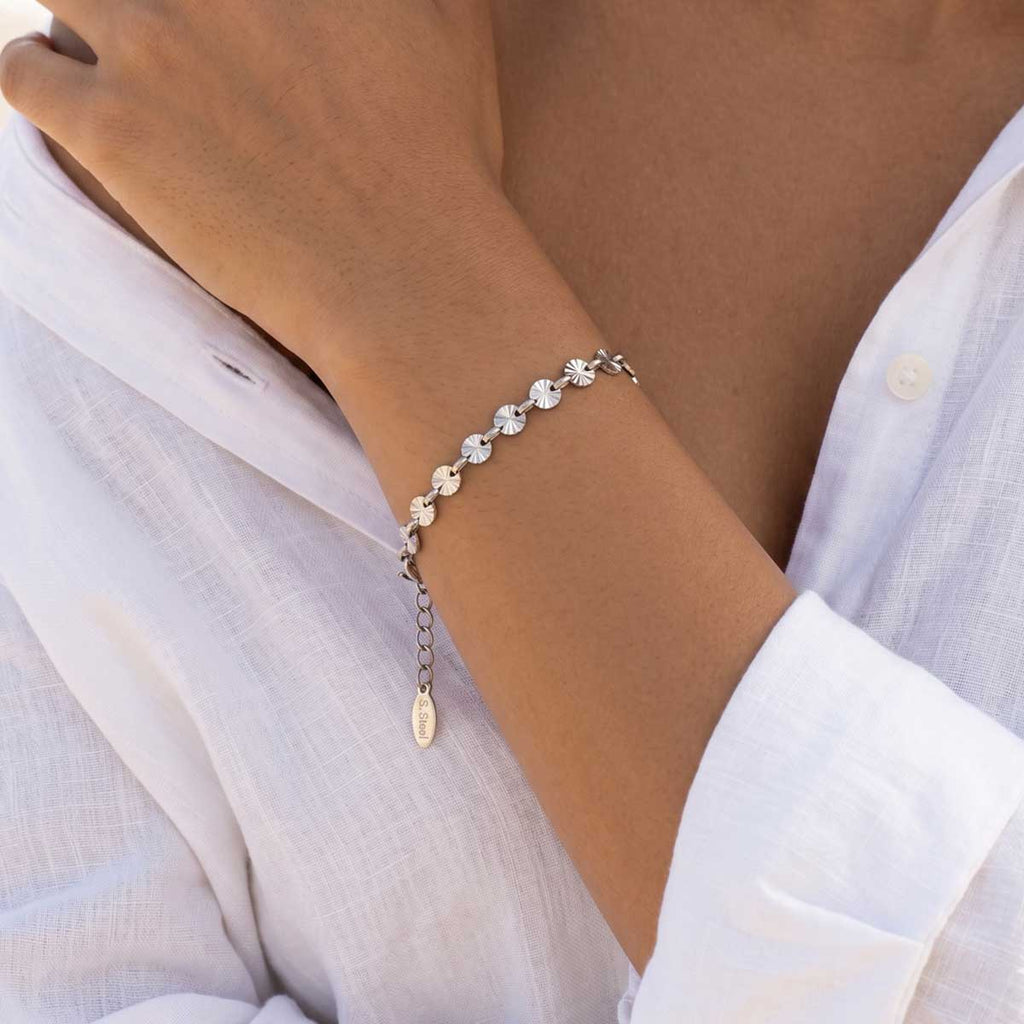Silberfarbenes Damen Armband am Handgelenk eines Models getragen.