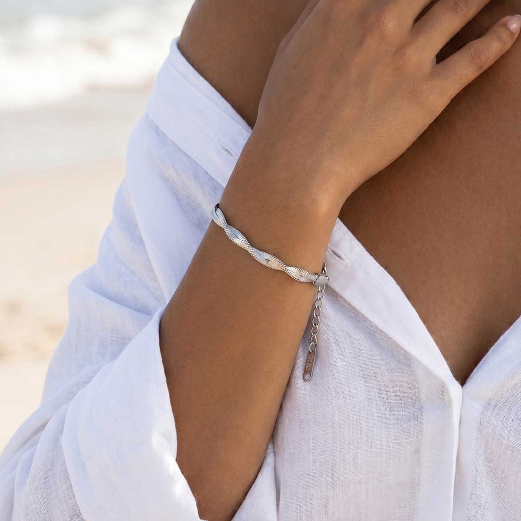 Silberfarbenes Damen Armband am Handgelenk eines Models getragen.