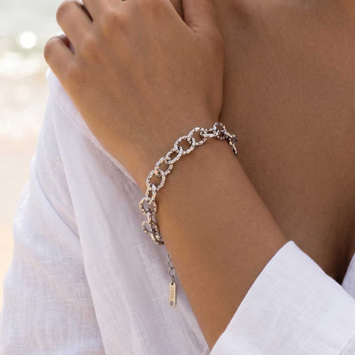 Silberfarbenes Damen Armband am Handgelenk eines Models getragen.
