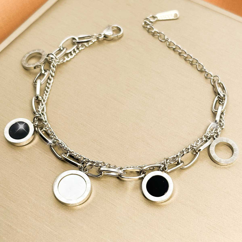 Silberfarbenes Damen-Armband aus Edelstahl im mehrlagigen Design mit runden Anhängern in kontrastierender schwarzer und silberfarbener Optik, Produktfoto