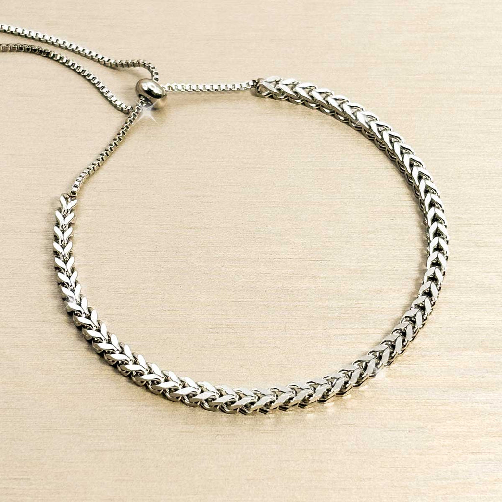 Silberfarbenes Edelstahl-Armband für Damen im markanten Fischgräten-Design mit einem praktischen, flexiblen Zugverschluss, Studioaufnahme.