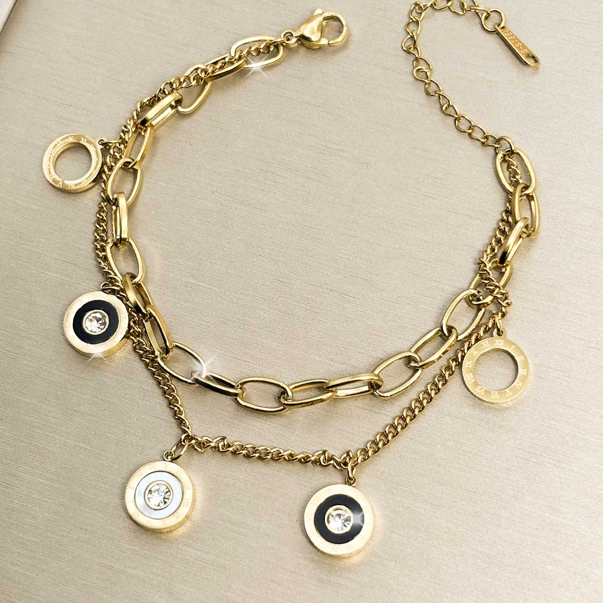 Goldfarbenes Damen-Armband aus Edelstahl im mehrreihigen Design mit glänzenden, runden Münz- und Ring-Anhängern, Produktfoto