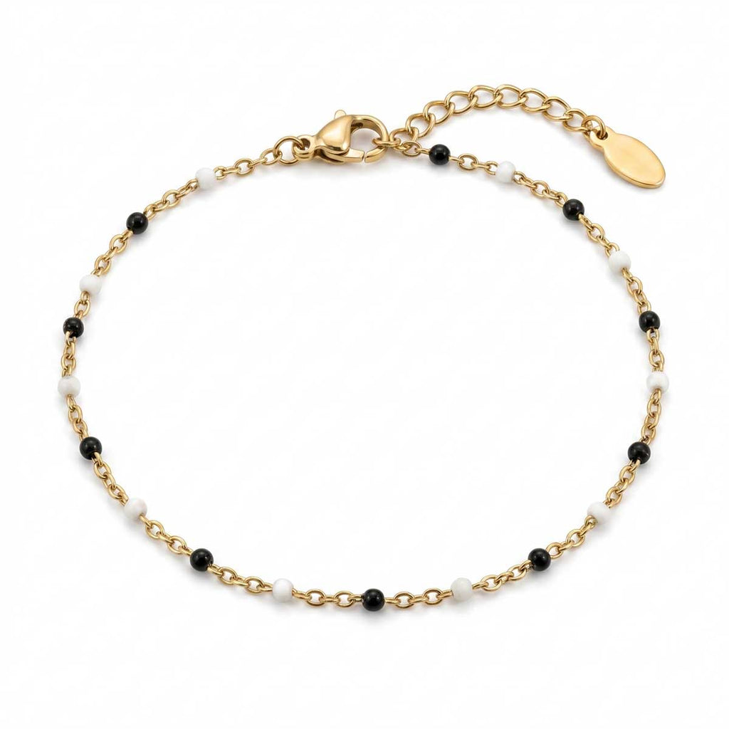 Filigranes goldfarbenes Damen-Armband aus Edelstahl, besetzt mit kleinen schwarz-weißen Perlen-Akzenten, Hauptfoto