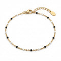 Filigranes goldfarbenes Damen-Armband aus Edelstahl, besetzt mit kleinen schwarz-weißen Perlen-Akzenten, Hauptfoto