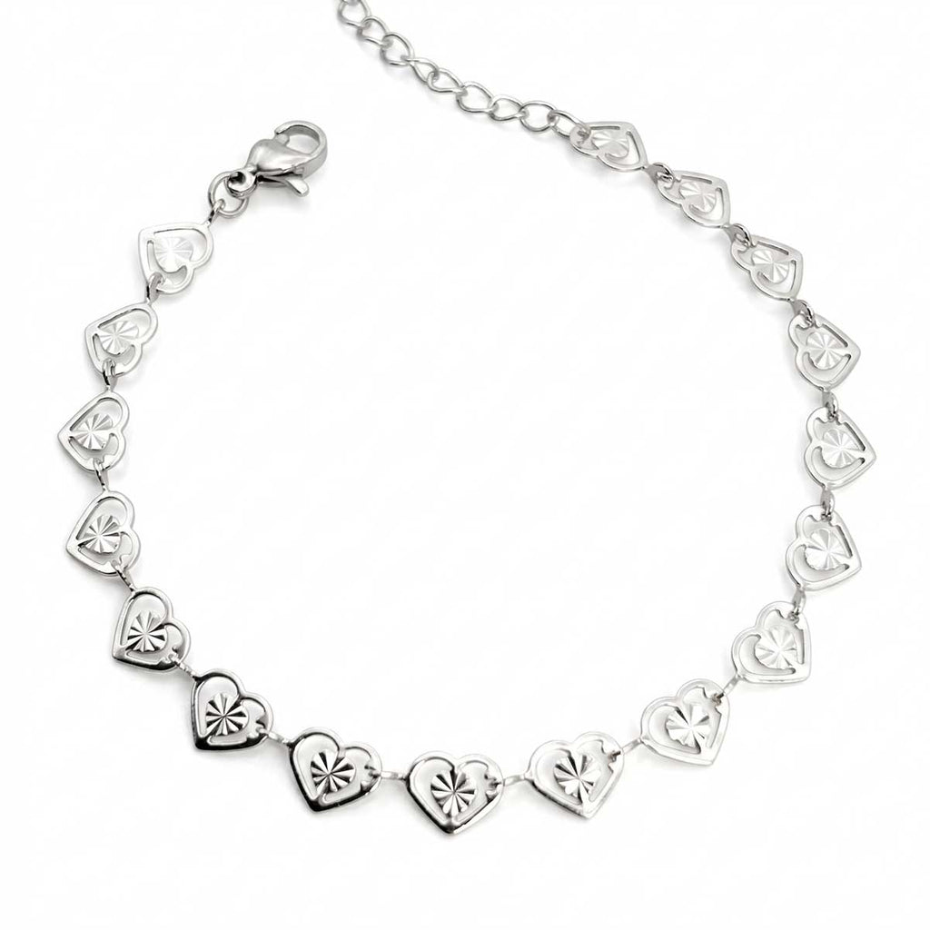 Silberfarbenes Damen-Armband aus Edelstahl, zusammengesetzt aus einer Reihe kleiner, filigran gemusterter Herz-Glieder, Hauptfoto