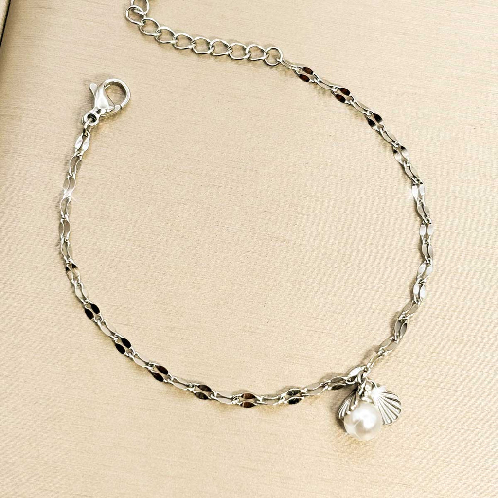 Silberfarbenes Damen-Armband aus Edelstahl mit kleinen, gedrehten Kettengliedern sowie einer weißen Perle und einem Muschel-Anhänger, Produktfoto