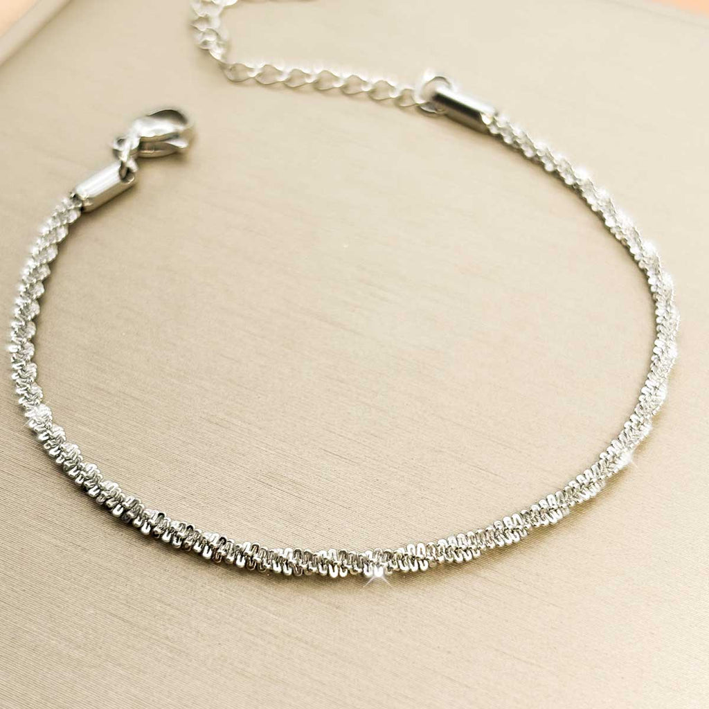 Silberfarbenes Damen-Armband aus Edelstahl mit einer intensiv strukturierten, glitzernden Ketten-Struktur, Produktfoto.
