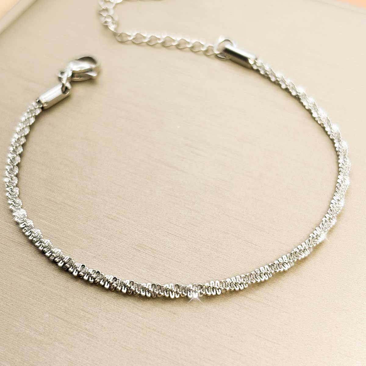 Silberfarbenes Damen-Armband aus Edelstahl mit einer intensiv strukturierten, glitzernden Ketten-Struktur, Produktfoto.