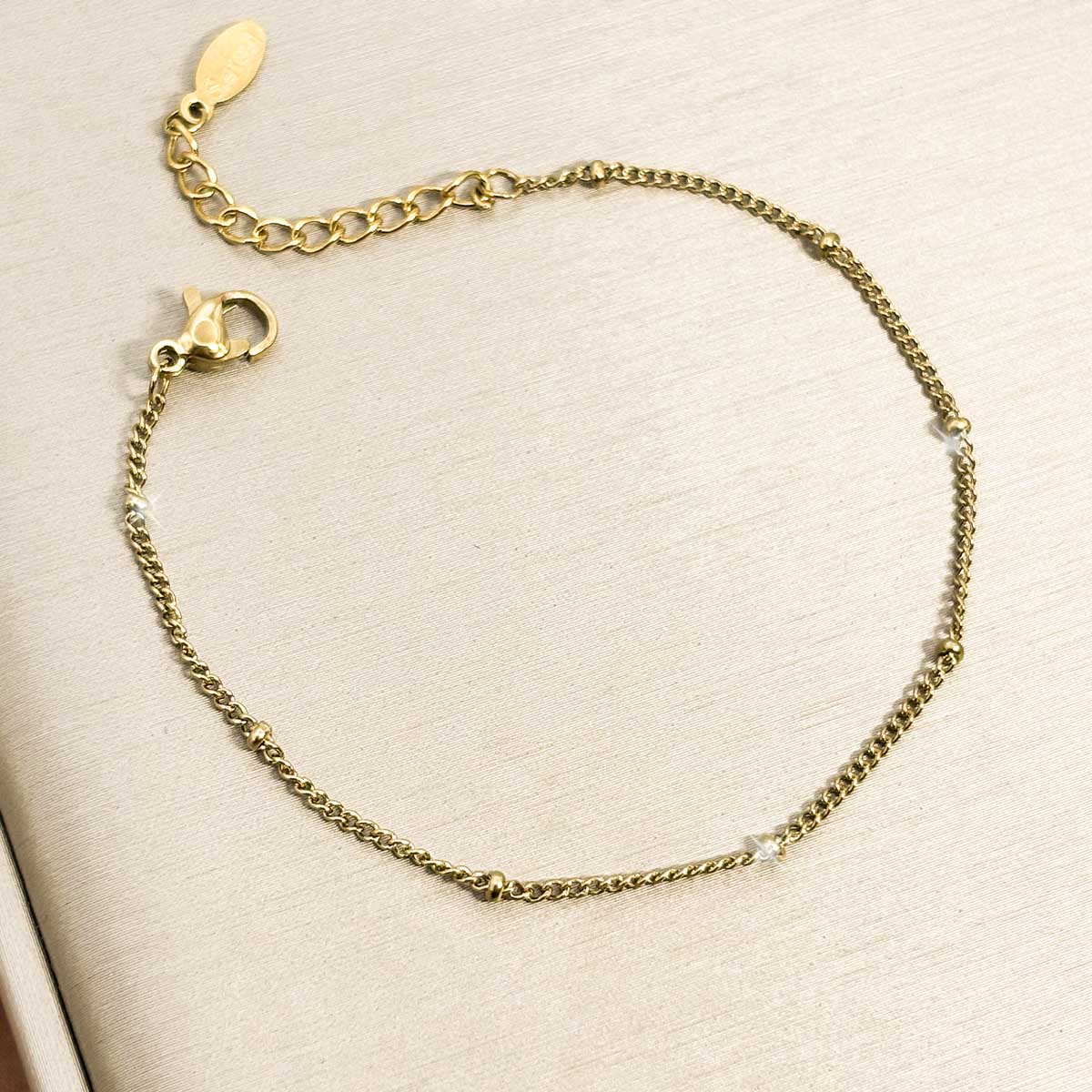 Goldfarbenes Damen-Armband aus Edelstahl mit dezent platzierten Mini-Kugeln an einer feinen Kette, Produktfoto