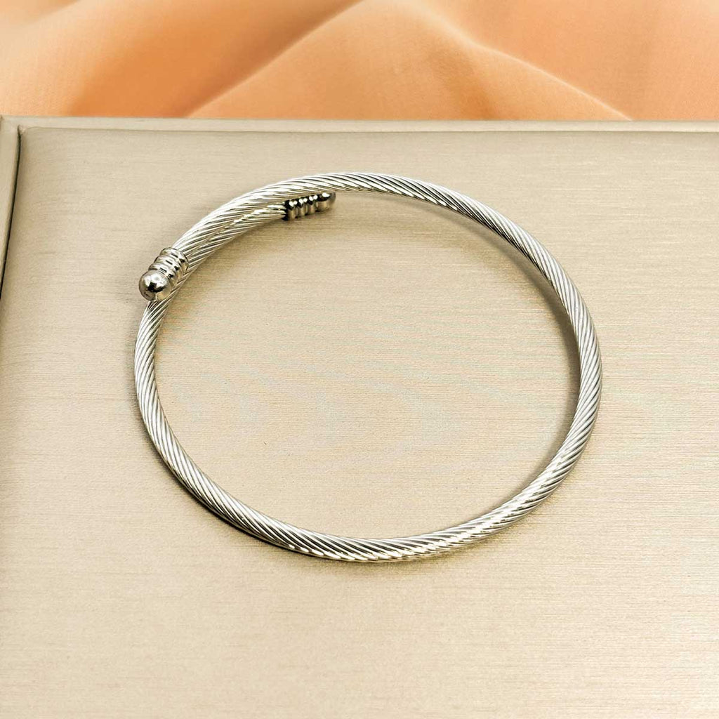 Silberfarbener Damen-Armreif aus Edelstahl im eleganten, flexibel gewickelten Kabel-Design, Nahaufnahme.