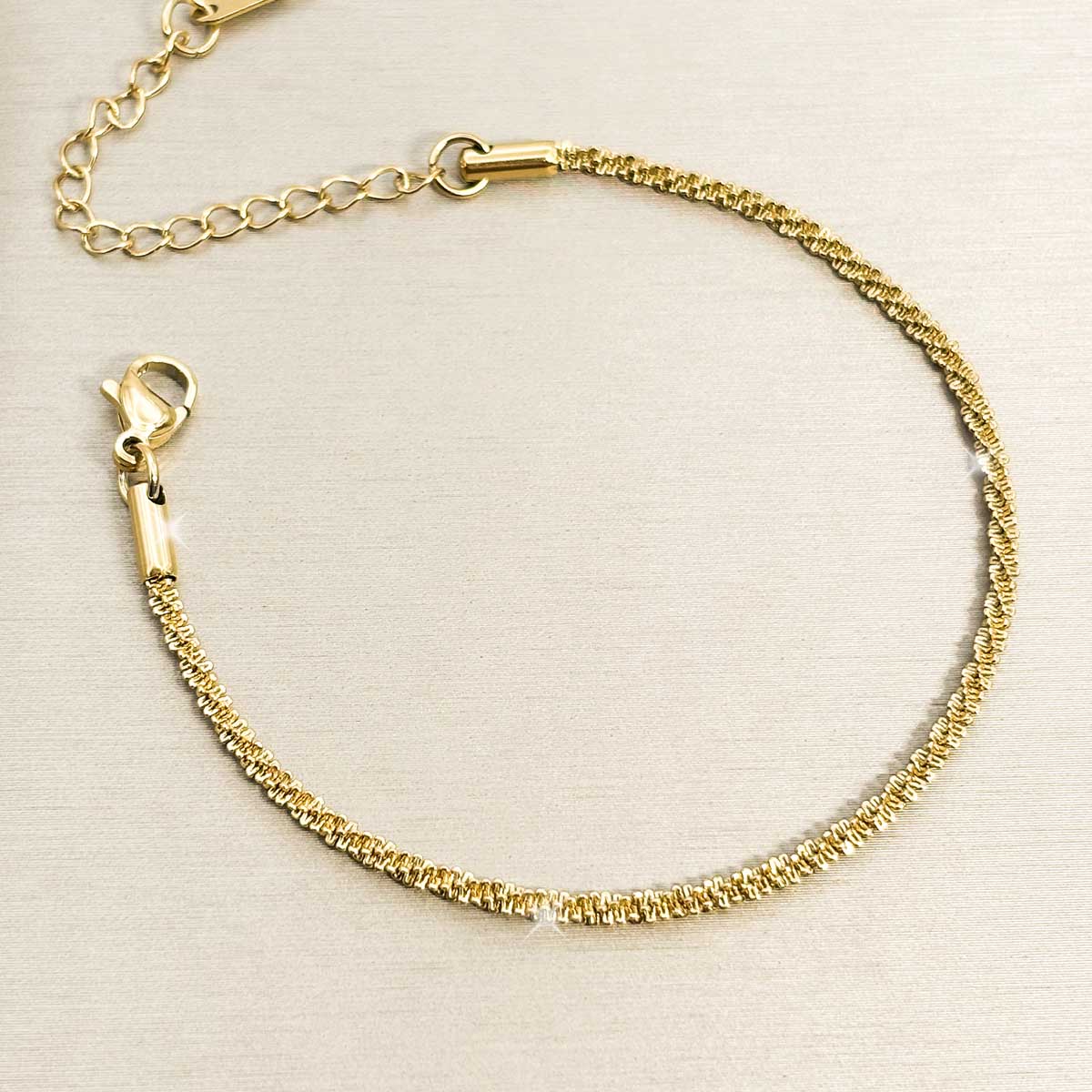 Goldfarbenes Damen-Armband aus Edelstahl mit einer intensiv strukturierten, funkelnden Ketten-Struktur, Vorderansicht.