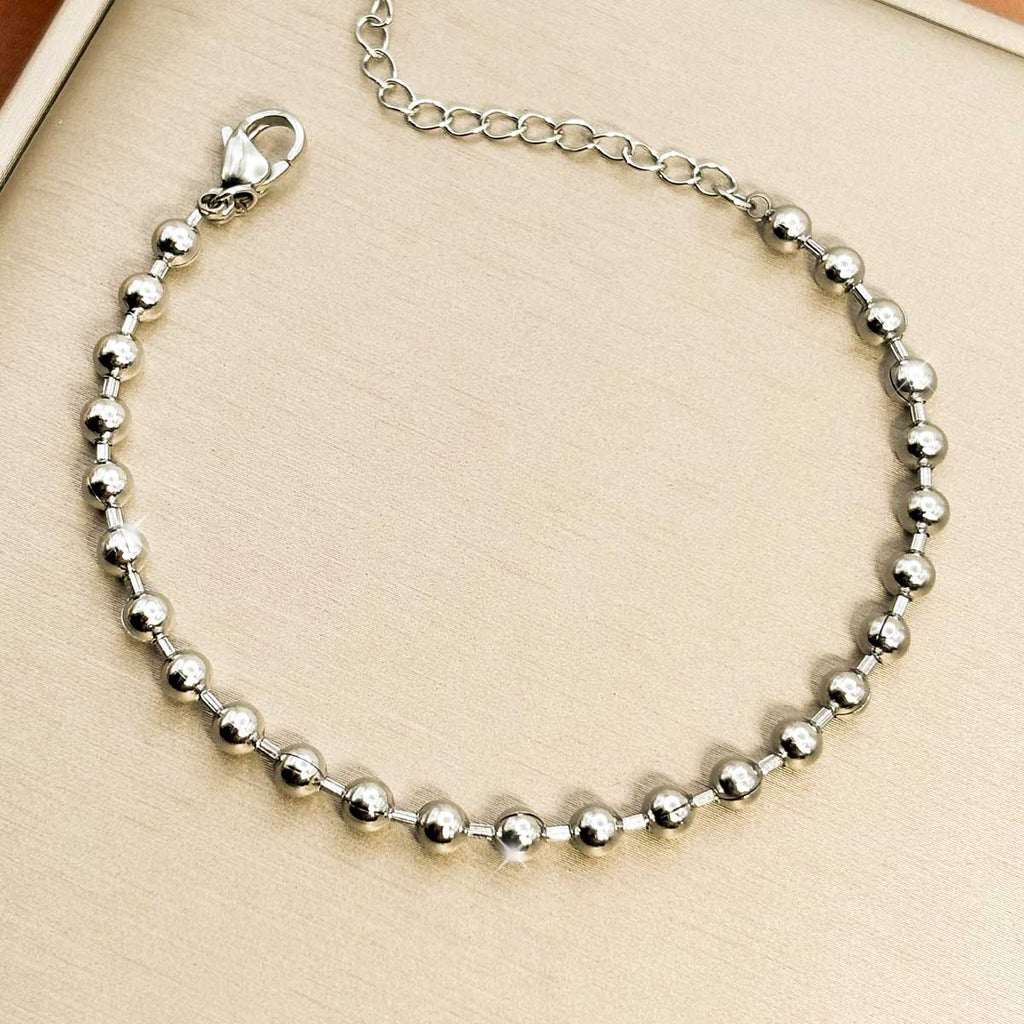 Silberfarbenes Damen-Armband aus Edelstahl, vollständig zusammengesetzt aus glänzenden Metallkugeln, Detail-Aufnahme.