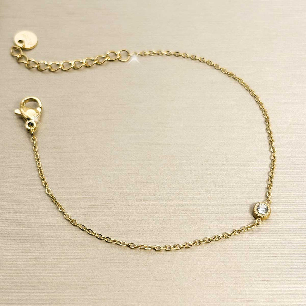 Goldfarbenes Damen-Armband aus Edelstahl aus feiner Kette mit einem winzigen, rund eingefassten Zirkonia-Stein, Produktfoto.