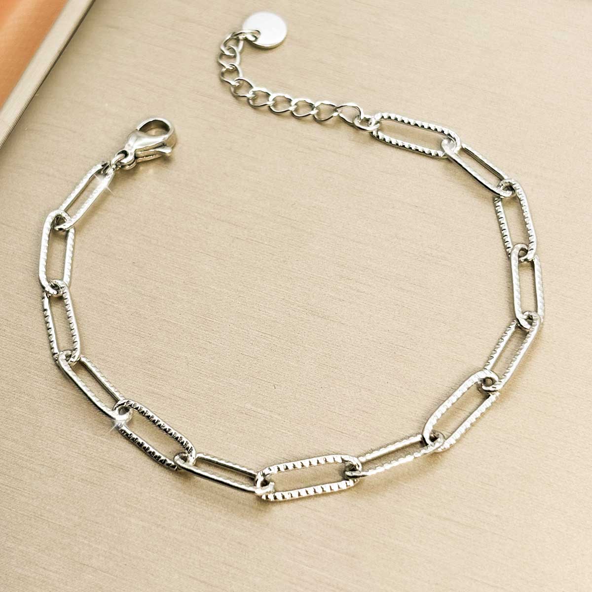 Silberfarbenes Damen-Armband aus Edelstahl mit länglichen, filigran gemusterten Kettengliedern, Vorderansicht.