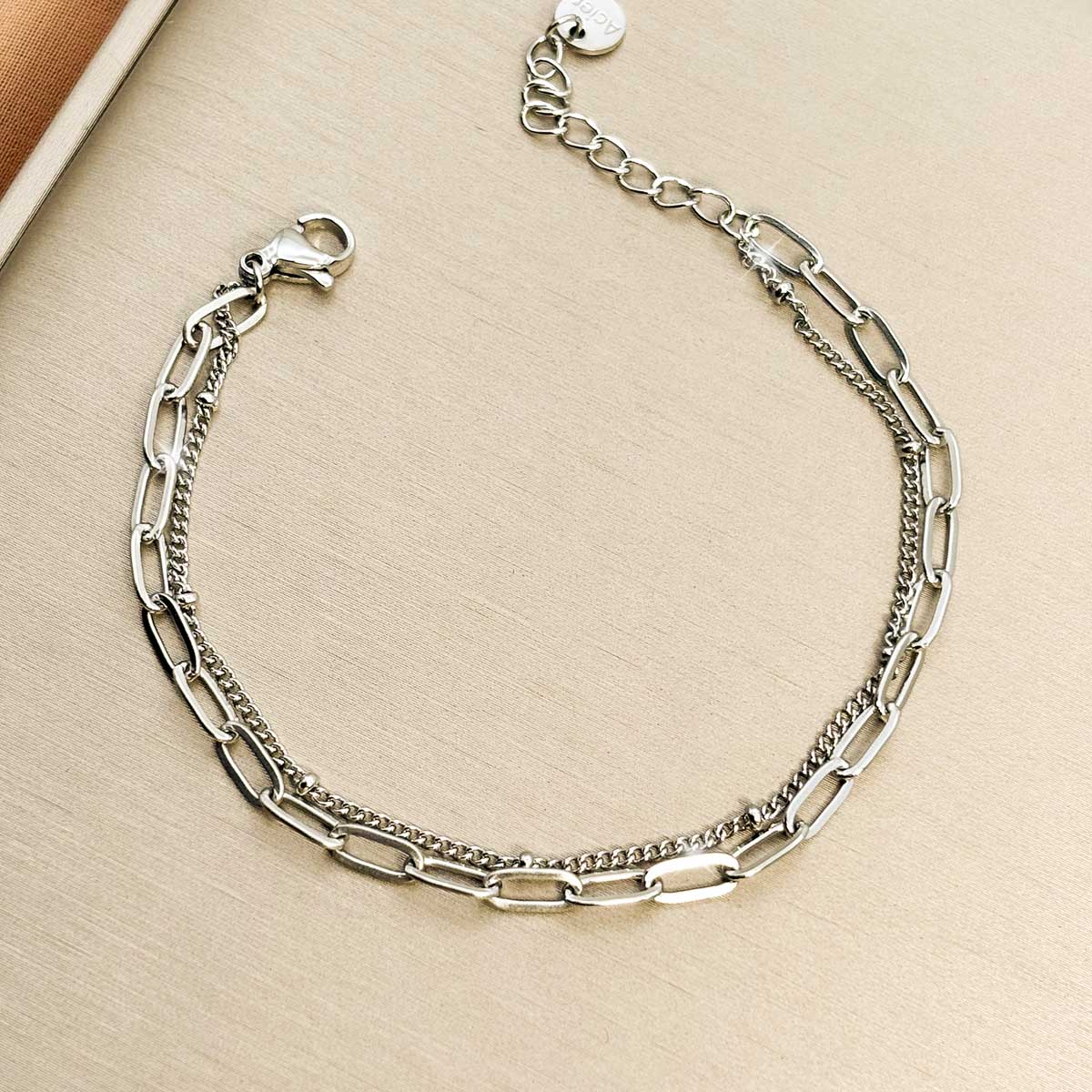 Silberfarbenes Damen-Armband aus Edelstahl im modischen Lagen-Look aus feinen Panzer- und Ankerkettengliedern, Produktfoto.