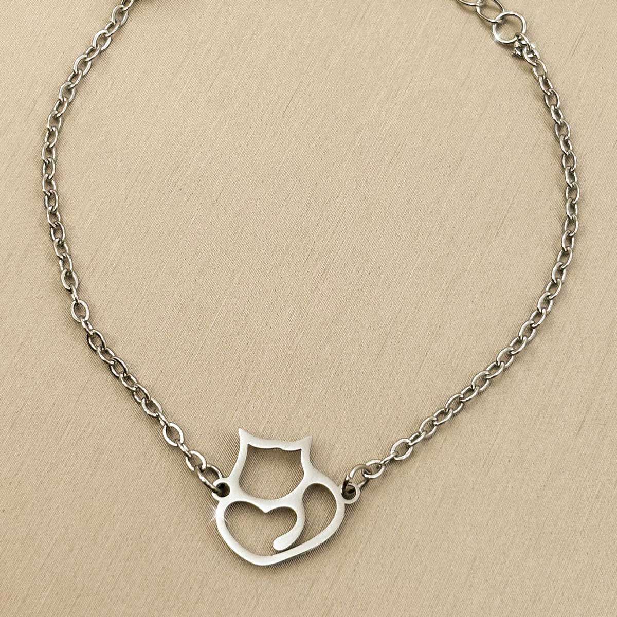 Kreatives silberfarbenes Damen-Armband aus Edelstahl mit einem filigranen Katzen-Anhänger, Produktfoto.