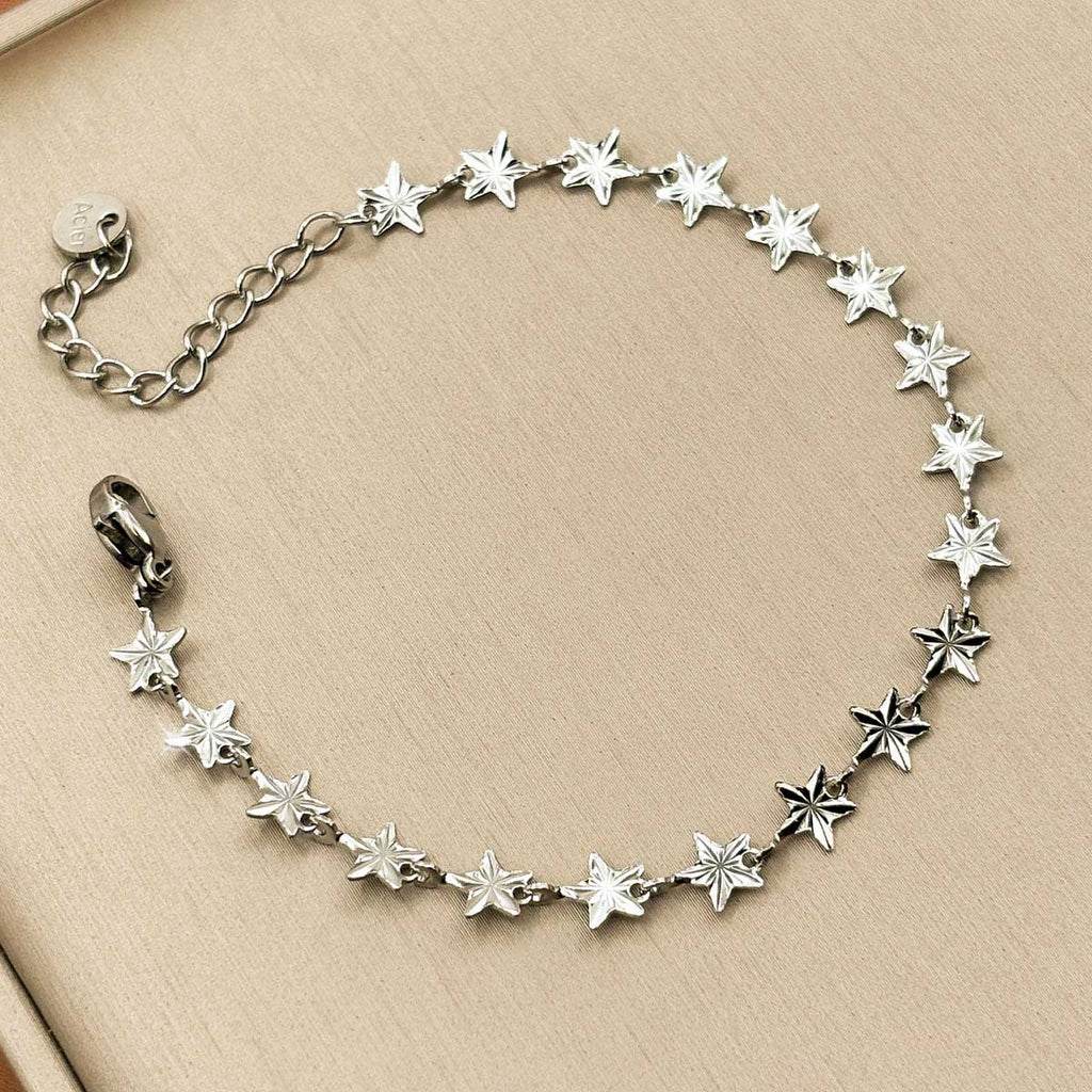 Silberfarbenes Edelstahl-Armband für Damen, bestehend aus einer Kette kleiner, funkelnder Sterne, Studioaufnahme.