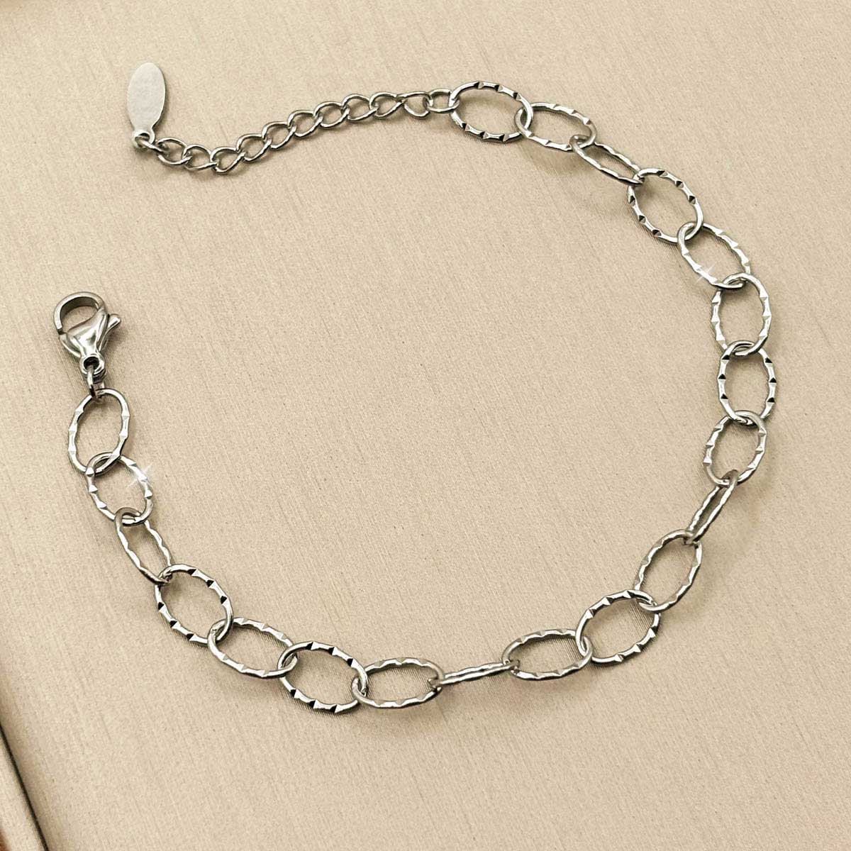 Silberfarbenes Damen-Armband aus Edelstahl mit gemusterten, länglichen Kettengliedern, Nahaufnahme.