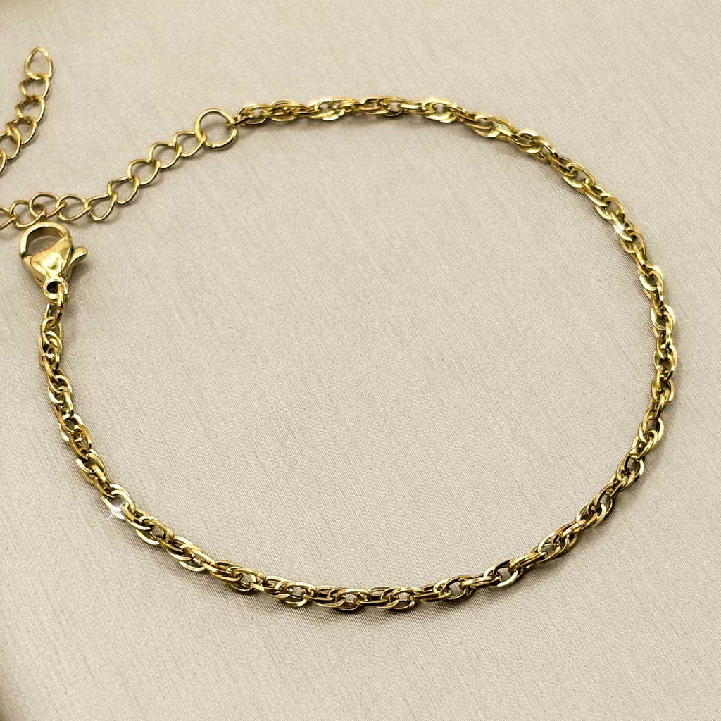 Goldfarbenes Damen-Armband aus Edelstahl mit einer feinen, elegant gedrehten Kettenstruktur, Vorderansicht.
