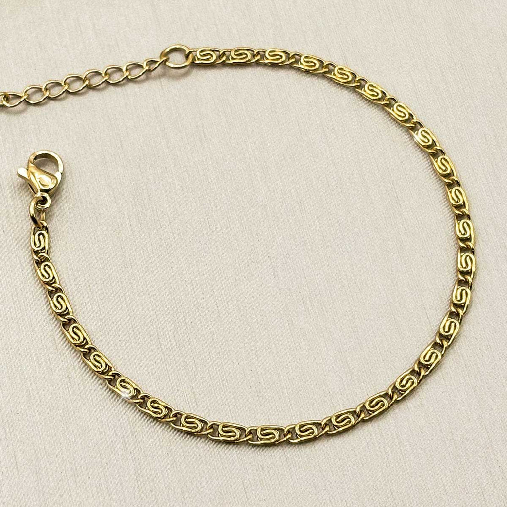 Goldfarbenes Damen-Armband aus Edelstahl mit flach strukturierten, gemusterten Kettengliedern, Detail-Aufnahme.