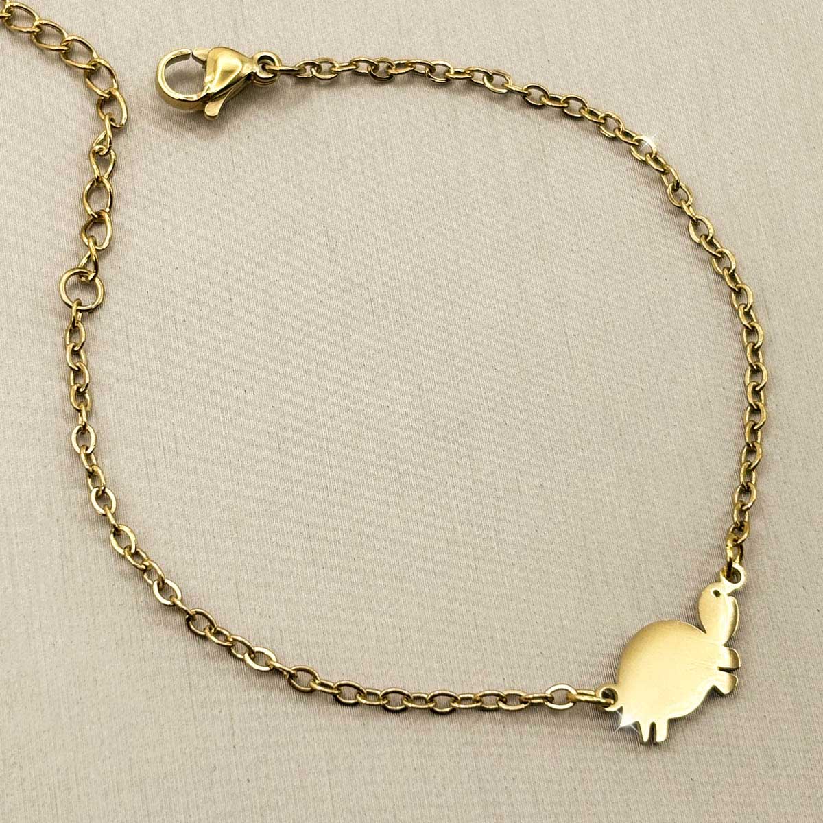 Goldfarbenes Damen-Armband aus Edelstahl mit einem minimalistischen Schildkröten-Anhänger, Produktfoto