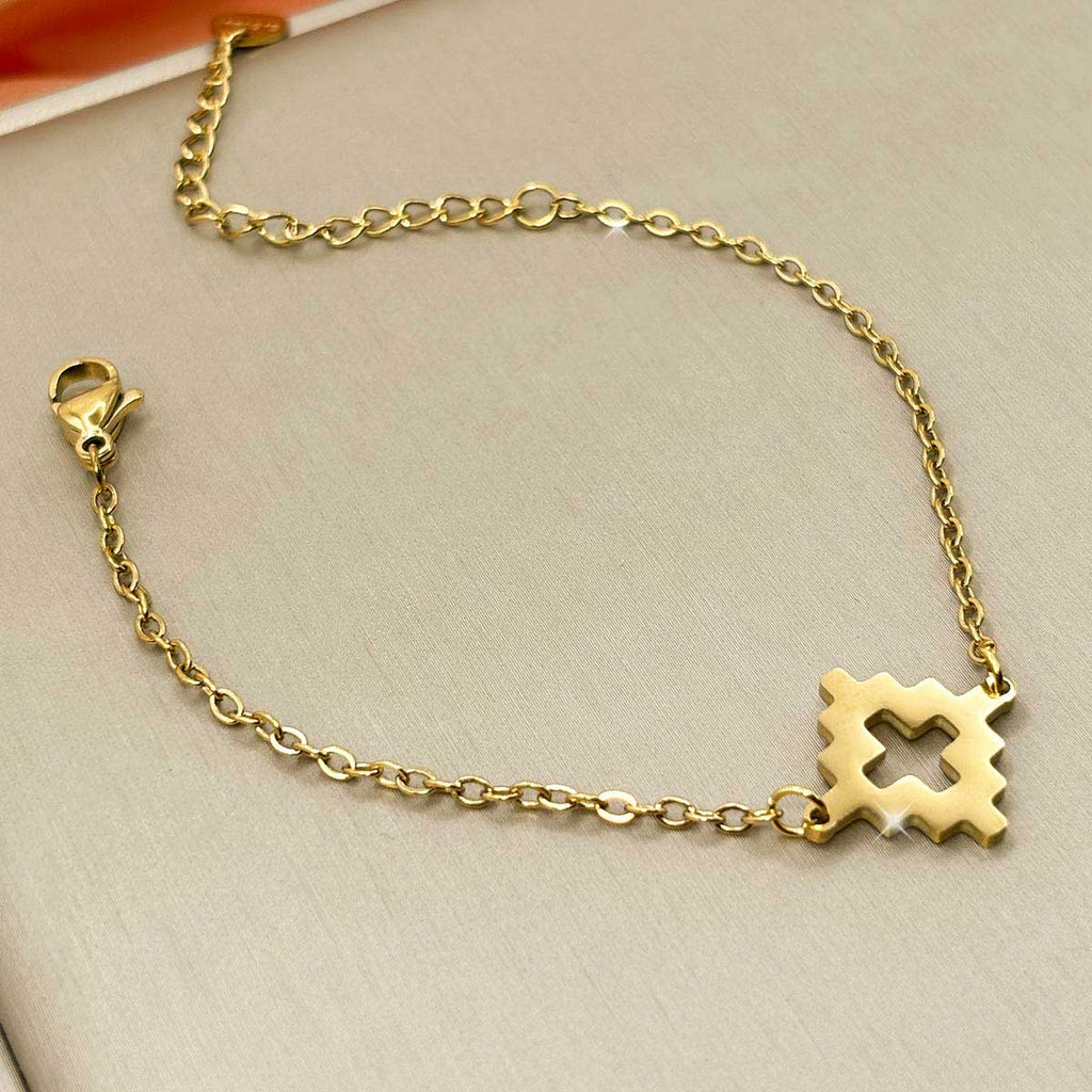 Goldfarbenes Damen-Armband aus Edelstahl mit einem ausgestanzten, geometrischen Rauten-Element, Nahaufnahme.
