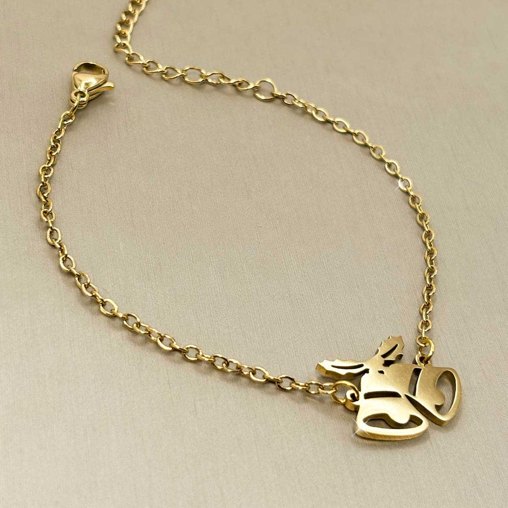 Goldfarbenes Edelstahl-Armband für Damen mit einem festlichen Motiv aus zwei Weihnachtsglocken, Produktbild.