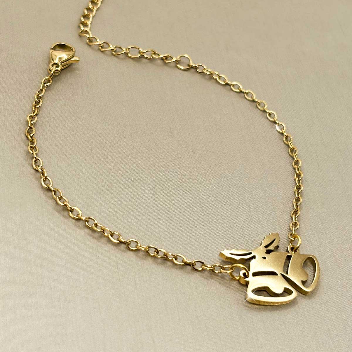 Goldfarbenes Edelstahl-Armband für Damen mit einem festlichen Motiv aus zwei Weihnachtsglocken, Produktbild.
