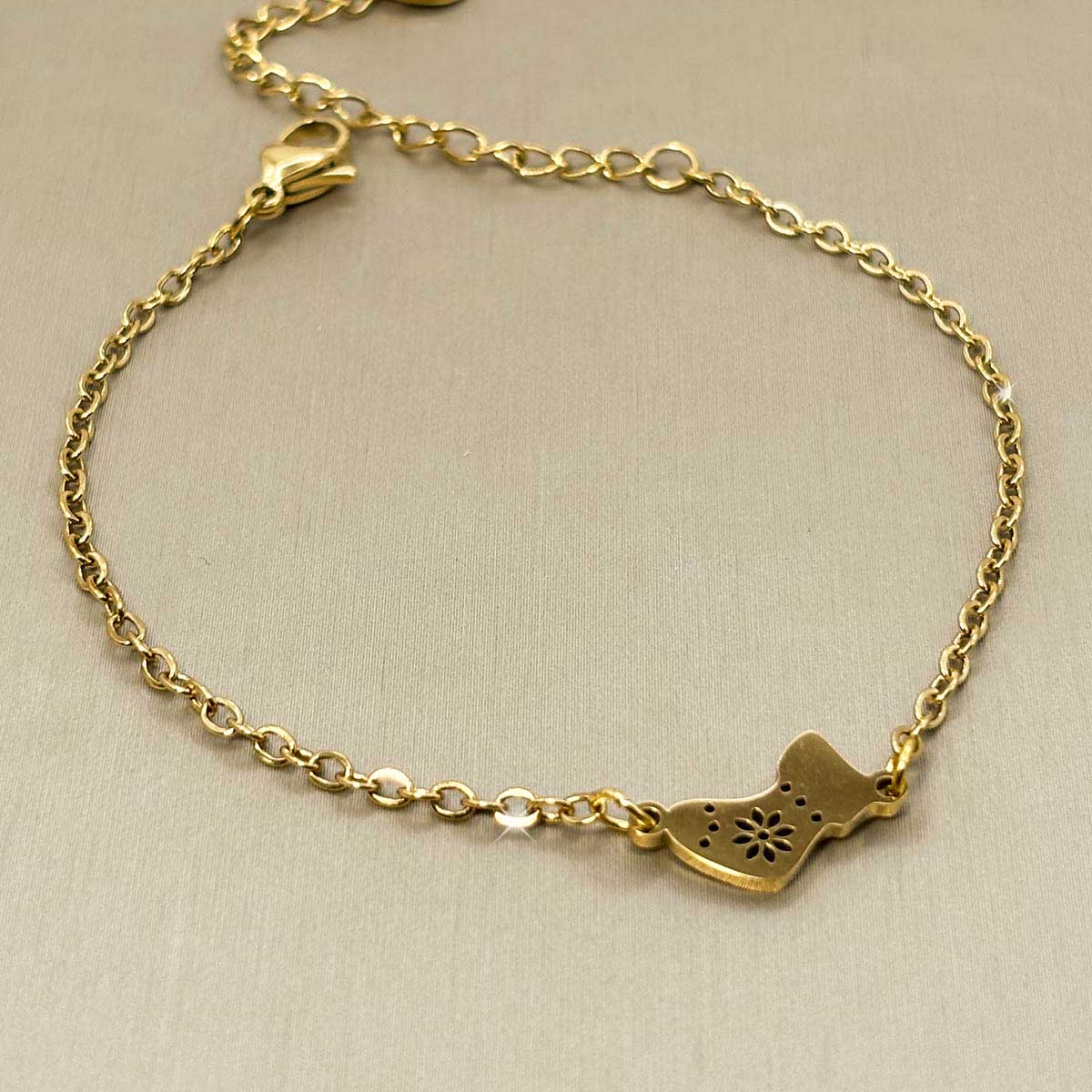 Goldfarbenes Edelstahl-Armband für Damen mit einem festlichen Motiv aus einer Weihnachtssocke, Produktbild.