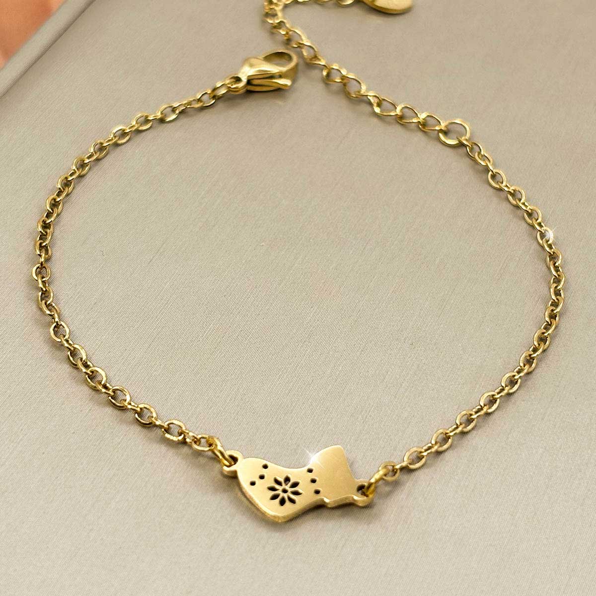 Goldfarbenes Edelstahl-Armband für Damen mit einem festlichen Motiv aus einer Weihnachtssocke, Vorderansicht.