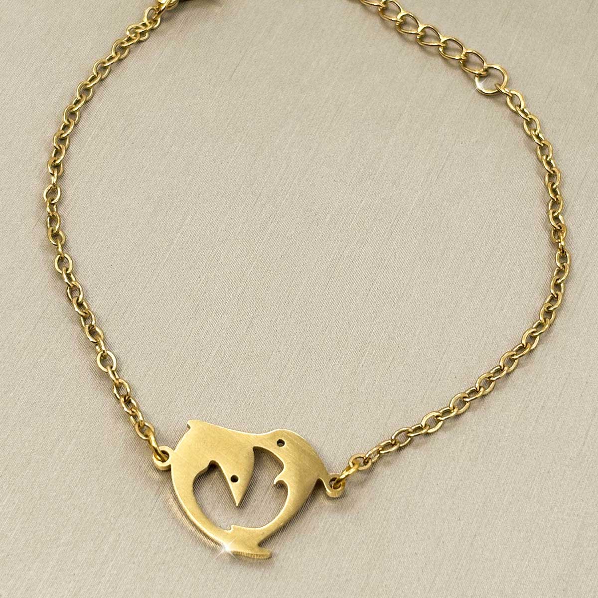 Goldfarbenes Edelstahl-Armband für Damen mit einem elegant geschwungenen Delfin-Element, Produktfoto