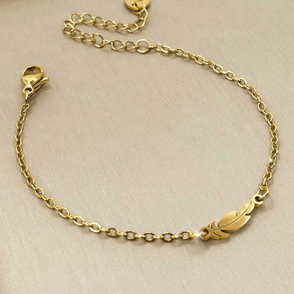 Filigranes goldfarbenes Edelstahl-Armband für Damen mit einer elegant geschwungenen Feder, Produktbild.