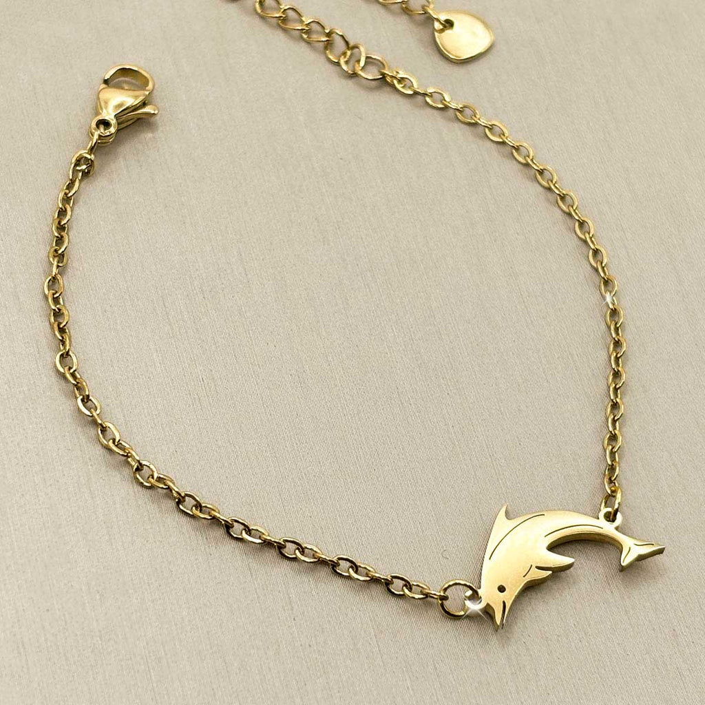 Goldfarbenes Damen-Armband aus Edelstahl mit einem grazilen Delfin-Anhänger, Vorderansicht.
