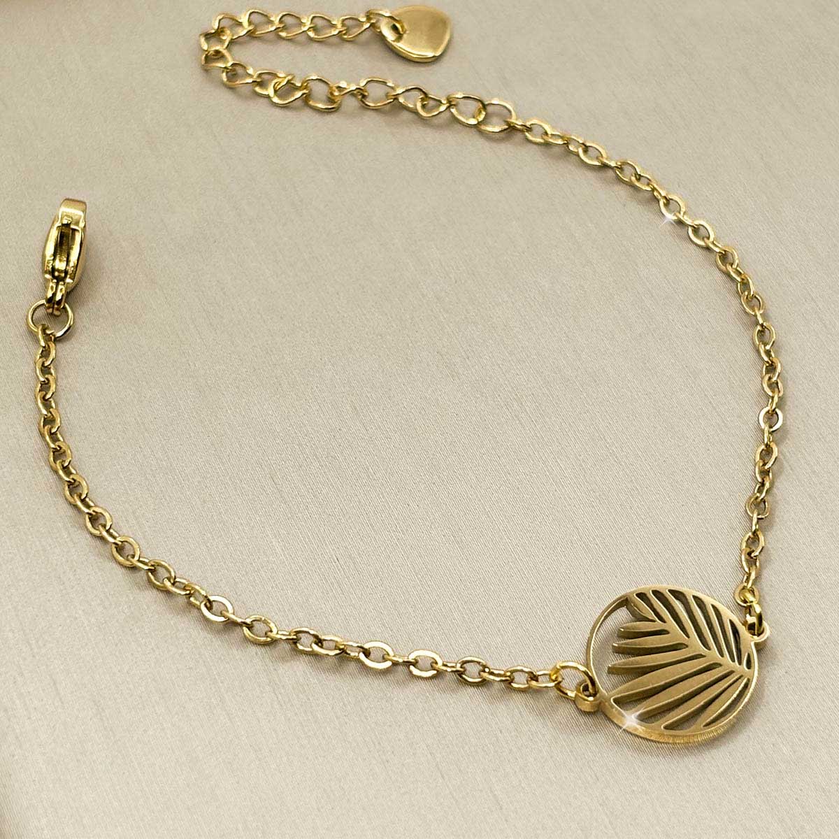 Goldfarbenes Damen-Armband aus Edelstahl mit einem runden, filigranen Palmenblatt-Anhänger, Produktfoto