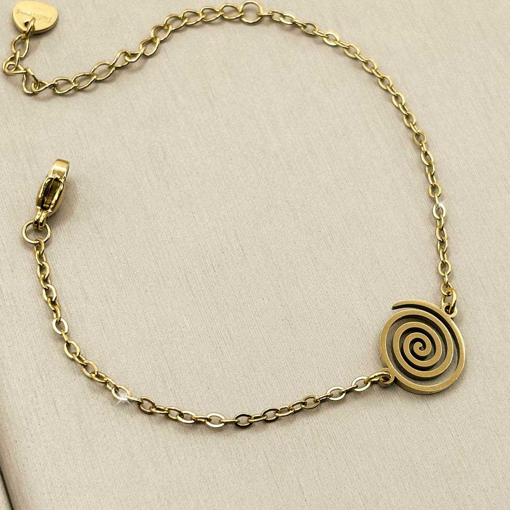 Goldfarbenes Damen-Armband aus Edelstahl mit einem runden, eingravierten Spiral-Anhänger, Produktfoto.