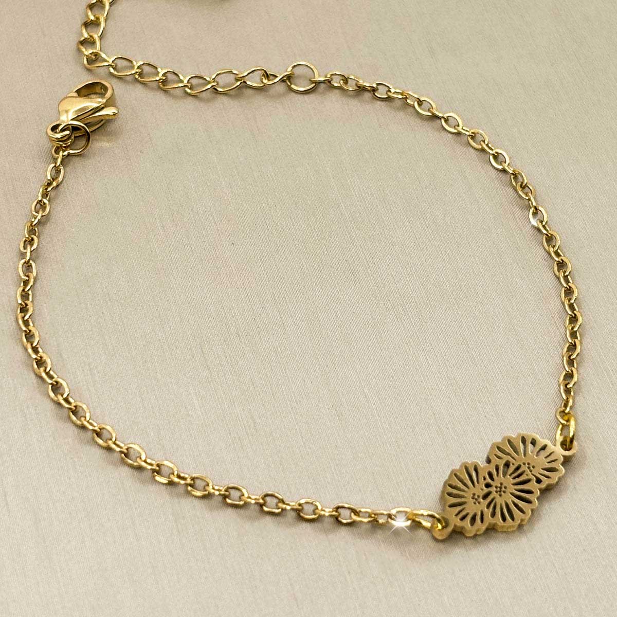 Goldfarbenes Edelstahl-Armband für Damen mit einem filigranen Motiv aus zwei ineinandergreifenden Blüten, Produktbild.