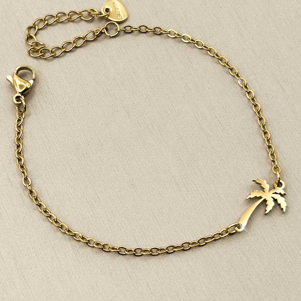 Goldfarbenes Edelstahl-Armband für Damen mit einer filigranen, elegant geschwungenen Palme, Studioaufnahme.
