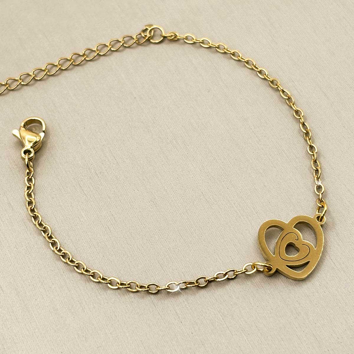 Romantisches goldfarbenes Damen-Armband aus Edelstahl mit einem offenen, mehrteiligen Herz-Anhänger, Produktfoto