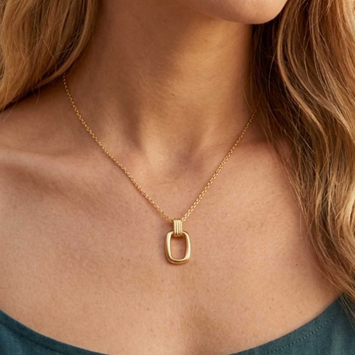 Goldfarbene Damen Halskette mit Anhänger am Hals eines Models getragen.