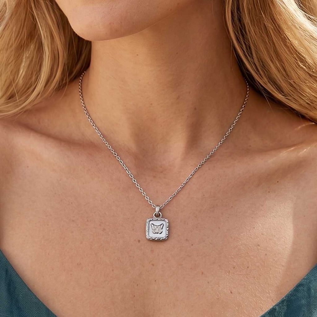 Silberfarbene Damen Halskette mit Anhänger am Hals eines Models getragen.